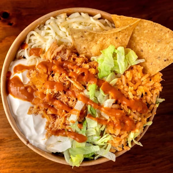 A Crazy King Burrito bowl with chicken, rice, lettuce, cheese, sour cream, salsa, and tortilla chips.